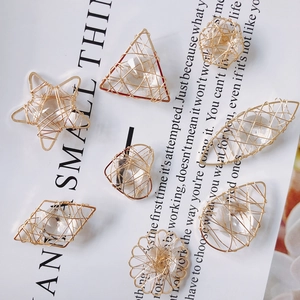 Dettaglio di ciondoli geometrici in filo d'oro KC con cristalli di zircone trasparente