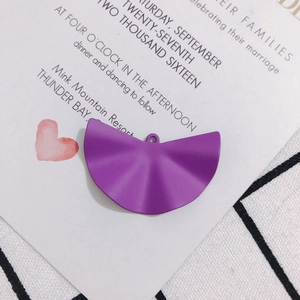Makroaufnahme von lila matten fächerförmigen Faltenanhängern für DIY-Schmuck mit Loch