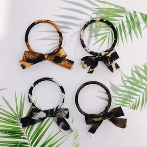Set of 4 leopard print bow scrunchies in brown, beige, grey, and green textures