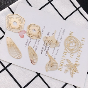 Detailaufnahme von goldenen DIY-Anhängern aus Legierung in Ginkgo- und Geometrieform