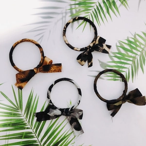 Set of four leopard print bow hair ties in brown, beige, grey, and olive green tones