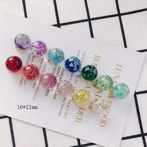 Macro shot of 16mm transparent glass balls with colorful dried flowers for DIY jewelry