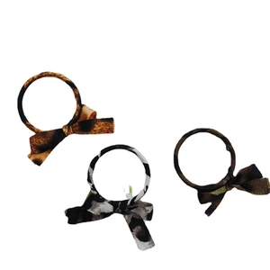 Three-piece set of fabric bow hair ties featuring leopard, cow, and camo prints