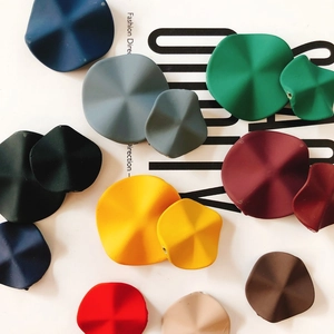Macro shot of colorful wavy resin discs for DIY earring making in assorted matte finishes