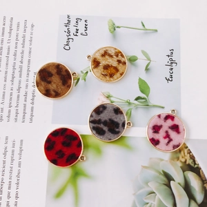 Macro detail of five leopard print faux fur round charms for DIY jewelry making