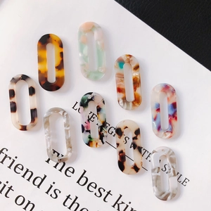 Macro shot of assorted colorful hollow oval acrylic pendants for handmade DIY jewelry