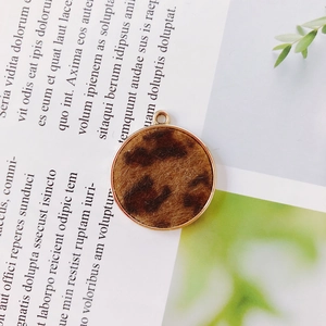 Detail of round leopard print plush pendant with golden alloy frame and hanging ring