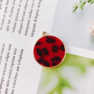 Macro view of round leopard print pendant with red flocking and gold metal frame