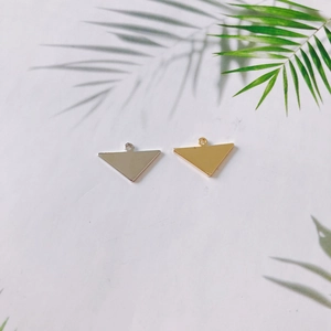 Vista dettagliata di ciondoli triangolari in metallo oro e argento per gioielli DIY