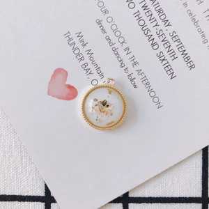 Macro detail of round gold-plated pendant with white resin and shell inlay for DIY jewelry