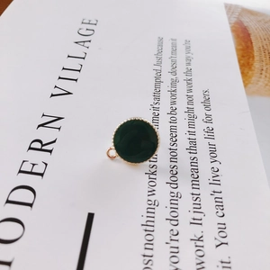 Makroaufnahme von dunkelgrünem Emaille-Anhänger mit Goldperlenrand für Schmuckherstellung