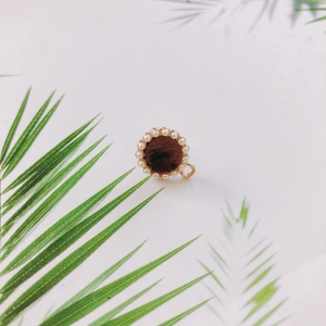 Détail macro du pendentif rond imprimé léopard avec bordure en perles et boucle dorée