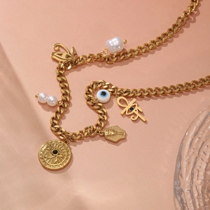 Goldene Gliederkette mit bösem Blick, Ankh, Pharao und Perlenanhängern auf Orange