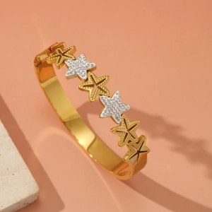 Bracciale rigido dorato con stelle, intarsio di cristalli e finitura opaca testurizzata