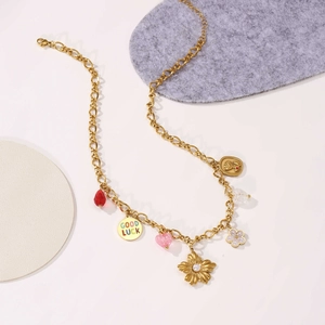 Goldene Halskette mit Perlen, roten Kristallblumen und Good Luck Anhängern verziert
