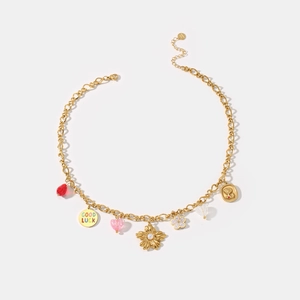 Goldene Bettelkette mit Blumenanhängern, Perlen und roten Kristallen auf weißem Grund