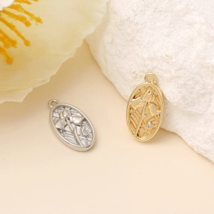 Vue macro de pendentifs ovales en métal avec relief floral et strass en or et argent