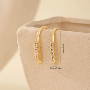 Macro view of gold-plated jewelry earring hook connector with 5 clear cubic zirconia gems