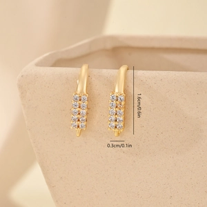 Macro detail of gold C-shaped earrings with micro-set cubic zirconia and size dimensions