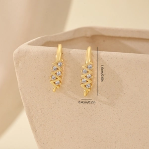 Macro detail of wave-shaped gold earrings with zircon stones and 1.6cm size dimensions