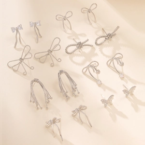 Silver bow knot and heart charm stud earrings set with sparkling zircon crystals