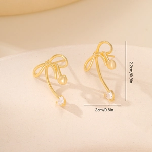 Macro detail of gold bow earrings with heart pendants and 2.2cm size measurement