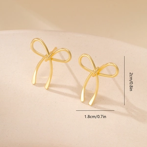 Detail view of gold bow knot earrings showing dimensions of 2cm by 1.8cm on display