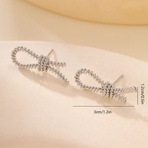 Detailed size view of silver bow earrings with spiral texture measuring 3cm by 1.2cm