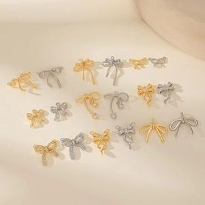 Detailed view of DIY bow-shaped metal jewelry pendants in gold and silver plating
