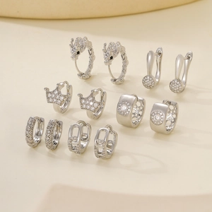 Selection of elegant silver-tone earrings with zircon stones on tiered display props