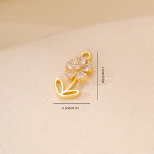 Macro shot of small gold flower pendant with zircons and 1.4x0.8cm size dimensions