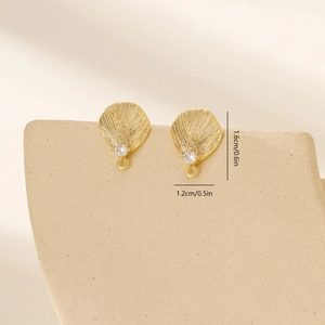 Macro view of gold leaf earrings with size dimensions and radial texture details