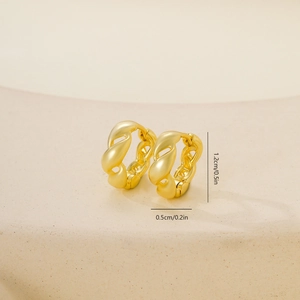 Detalle de pendientes dorados retorcidos con medidas de 1,2 cm de alto y 0,5 cm de ancho
