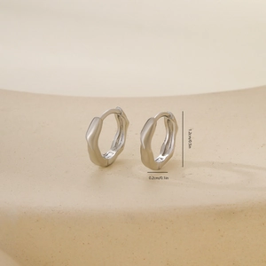 Detailed macro view of irregular ripple silver earring hoops with 1.2cm size measurement