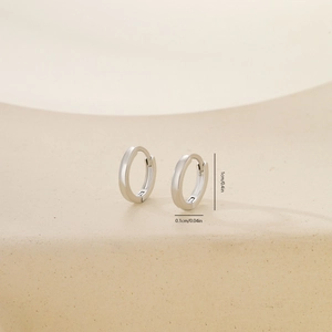 Detailed view of polished silver metal round hoop earrings with 1cm outer diameter dimensions