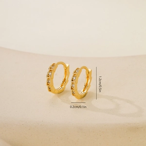 Vista de detalle de pendientes de aro dorados de 1,2 cm con textura de serpiente y circonita