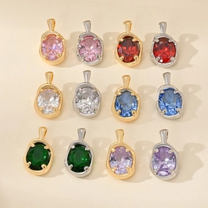 Detailed flat lay of 12-piece colorful oval gemstone pendants with gold and silver frames