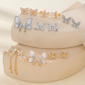 Detail view of butterfly earrings with cubic zirconia on wavy display stand