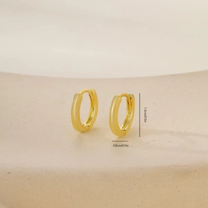 Close-up of golden huggie earrings with dimensions 1.3cm diameter and 0.2cm width