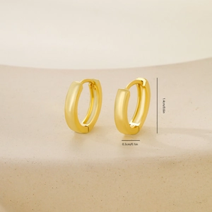 Macro shot of polished gold hoop earring detailing the 1.4cm diameter and secure hinge