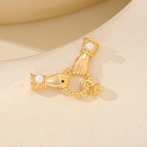 Detailed view of hand-shaped gold relief holding a twisted ring with pearls