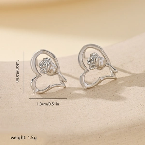 Close-up of heart-shaped hollow rose stud earring in silver finish with measurements