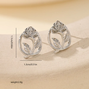 Detailed view of silver rose stud earrings with dimensions 1.7cm by 1.3cm on stone texture