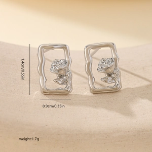 Macro shot of silver rose flower earrings in a rectangle frame with dimension measurements