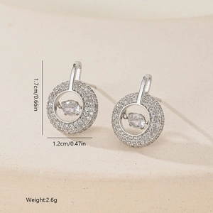 Macro detail of silver geometric earrings with micro-pave crystals and oval zircon drops