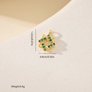 Detail view of 1.2cm gold star pendant with emerald green zircons and twisted rope texture