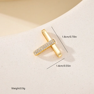 Macro shot of gold T-shape geometric pendant with white cubic zirconia and size details