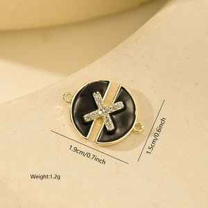 Detailed view of a round black enamel pendant with gold trim and X-shaped zircon stone