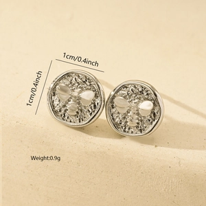 Detailed view of silver bee earrings with hammered texture and 1cm size markers