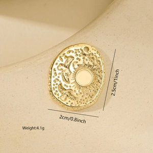 Detailed view of a gold oval pendant with sun and bird relief for DIY jewelry making